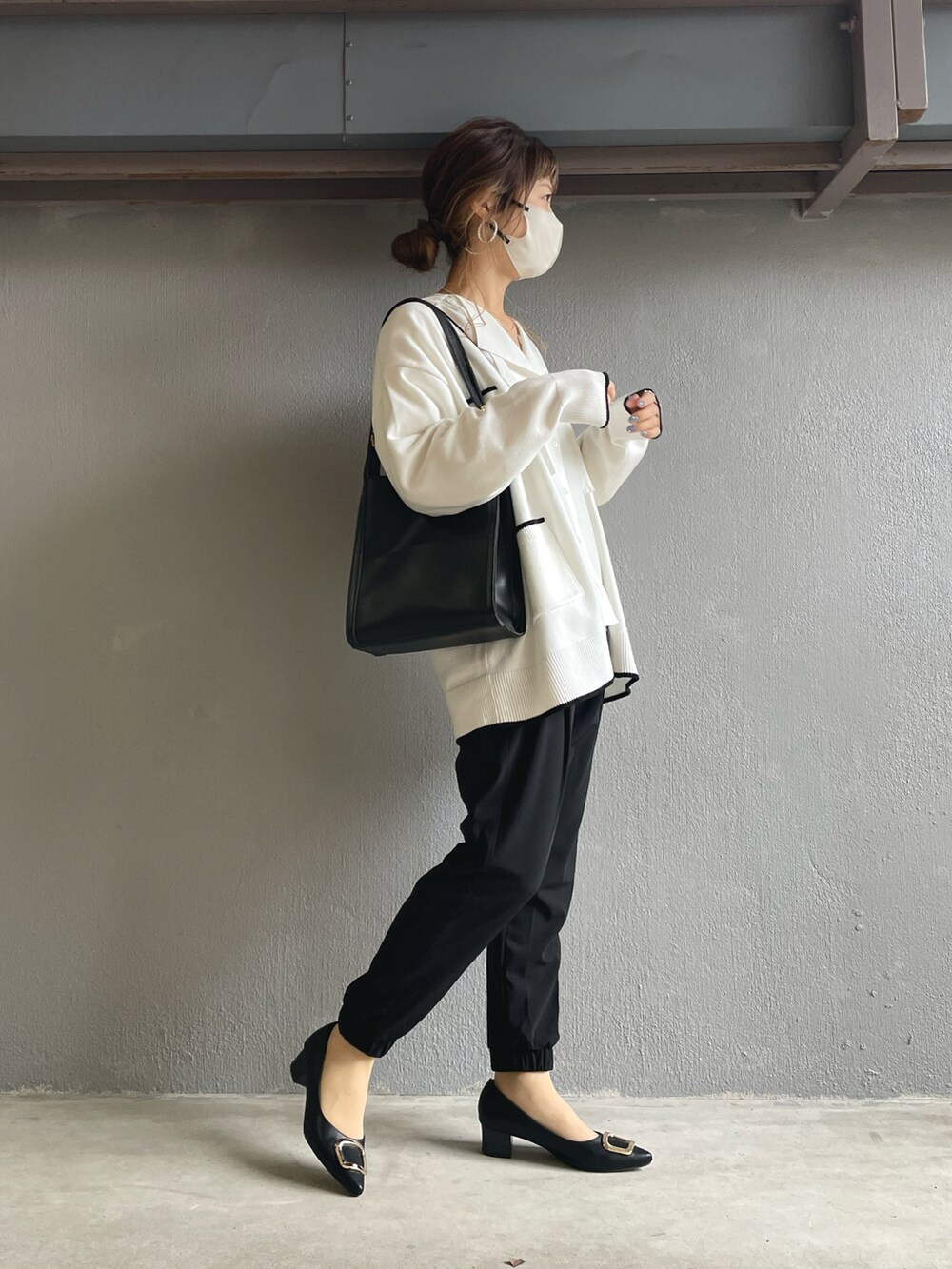 ブラック系のその他パンツ、ホワイト系のカーディガン/ボレロ、ブラック系のパンプスを着用したレディースの冬コーディネートの2枚目の写真