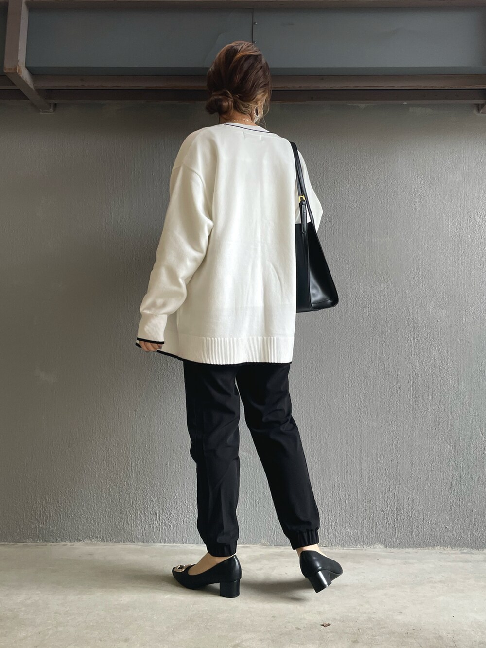 ブラック系のその他パンツ、ホワイト系のカーディガン/ボレロ、ブラック系のパンプスを着用したレディースの冬コーディネートの4枚目の写真