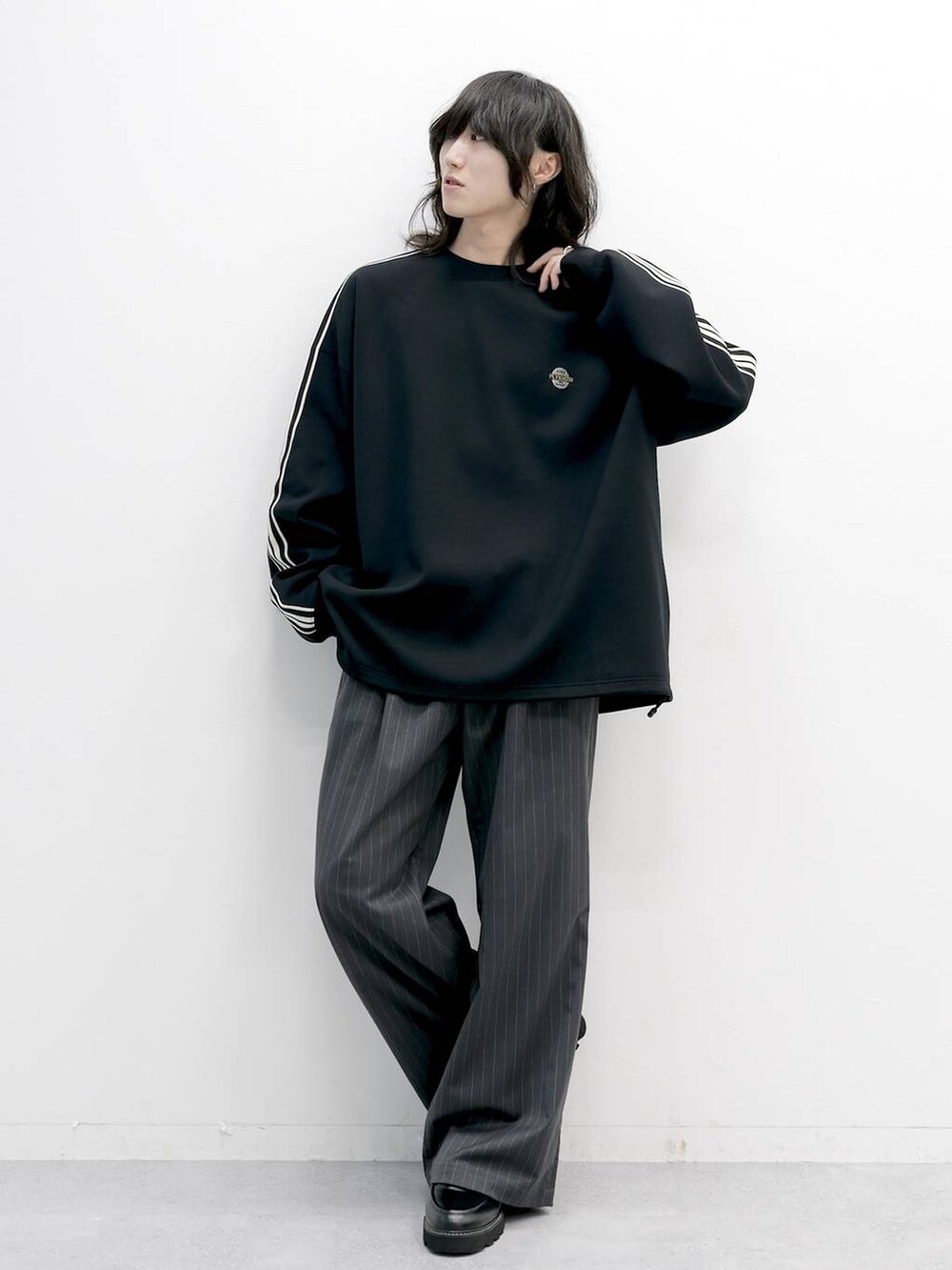 グレー系のスラックス、ブラック系のドレスシューズ、ブラック系のスウェットを着用したメンズの夏コーディネートの2枚目の写真