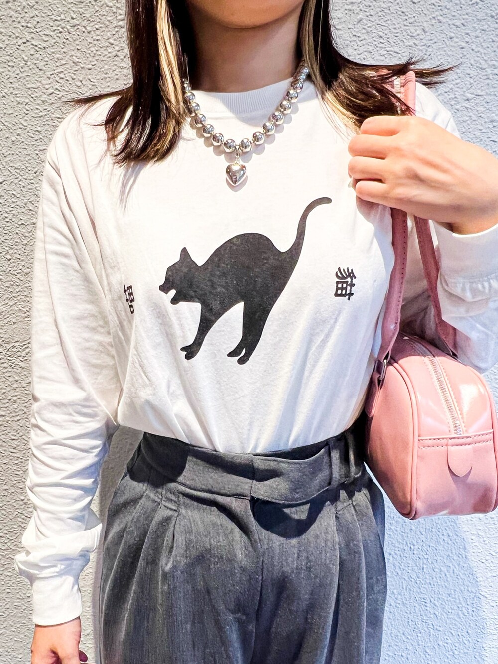 ホワイト系のTシャツ/カットソー、ピンク系のショルダーバッグを着用したレディースの秋コーディネートの2枚目の写真