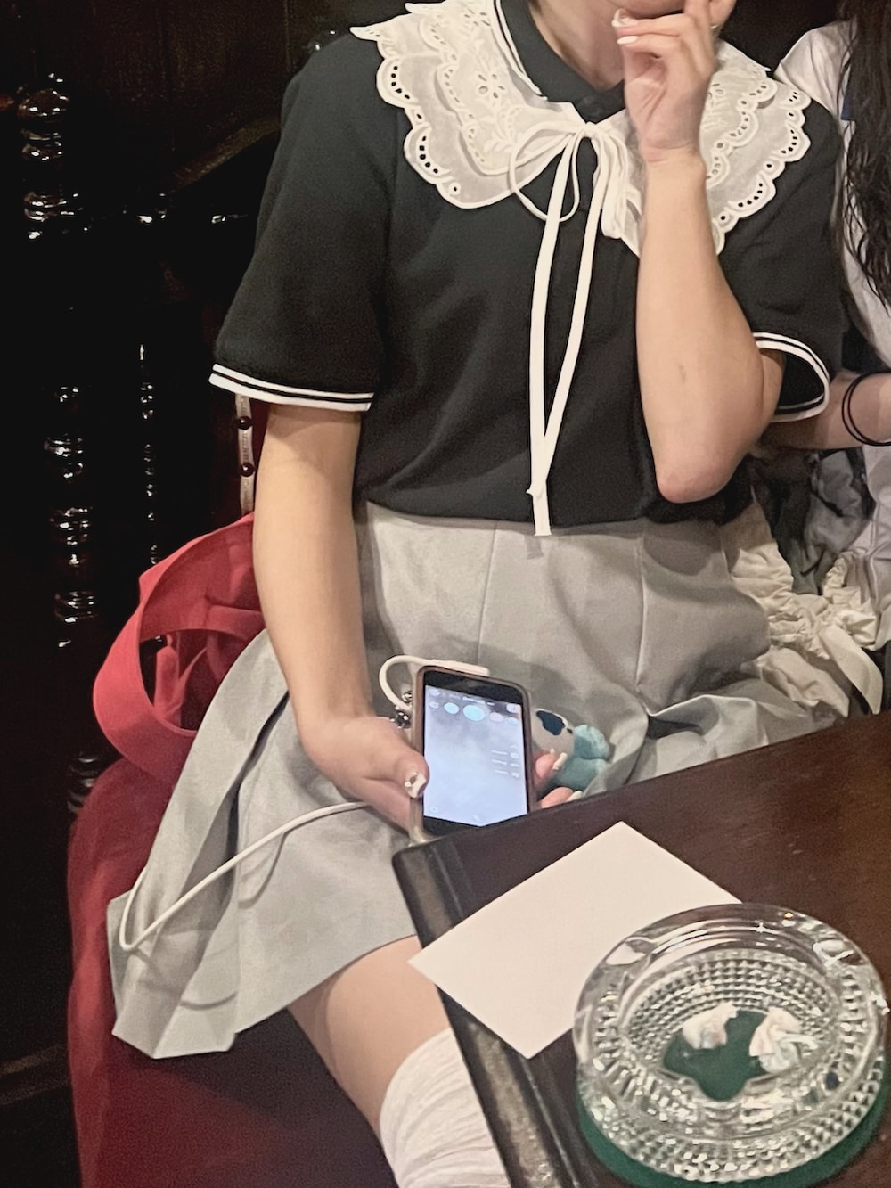 ブラック系のパンプス、レッド系のショルダーバッグ、ブラック系のポロシャツを着用したレディースの秋コーディネートの2枚目の写真