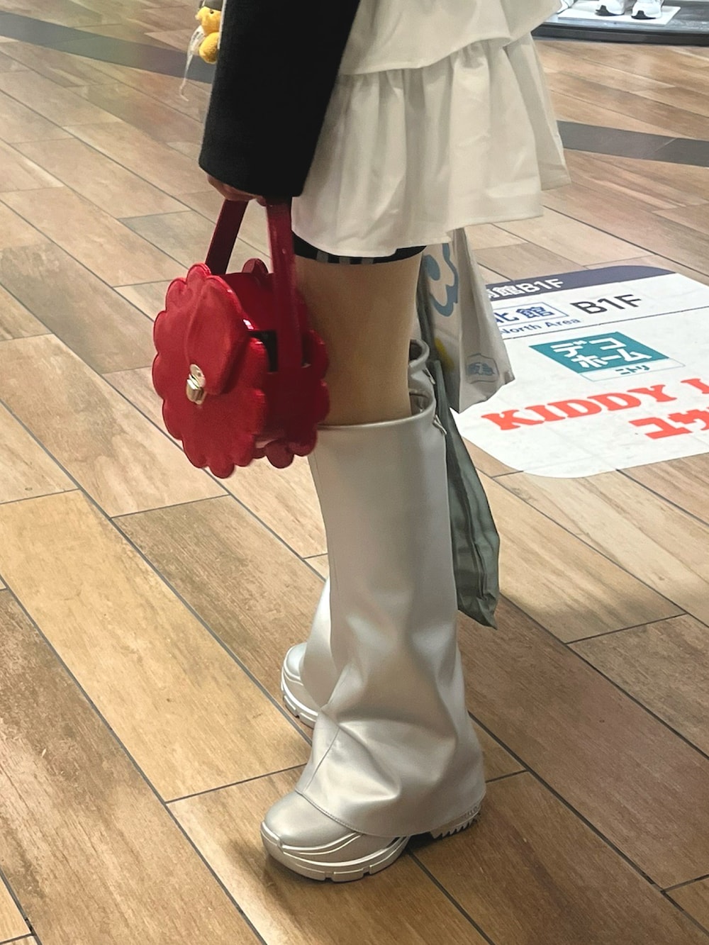 シルバー系のブーツ、レッド系のバッグ、ブラック系のテーラードジャケットを着用したレディースの冬コーディネートの2枚目の写真