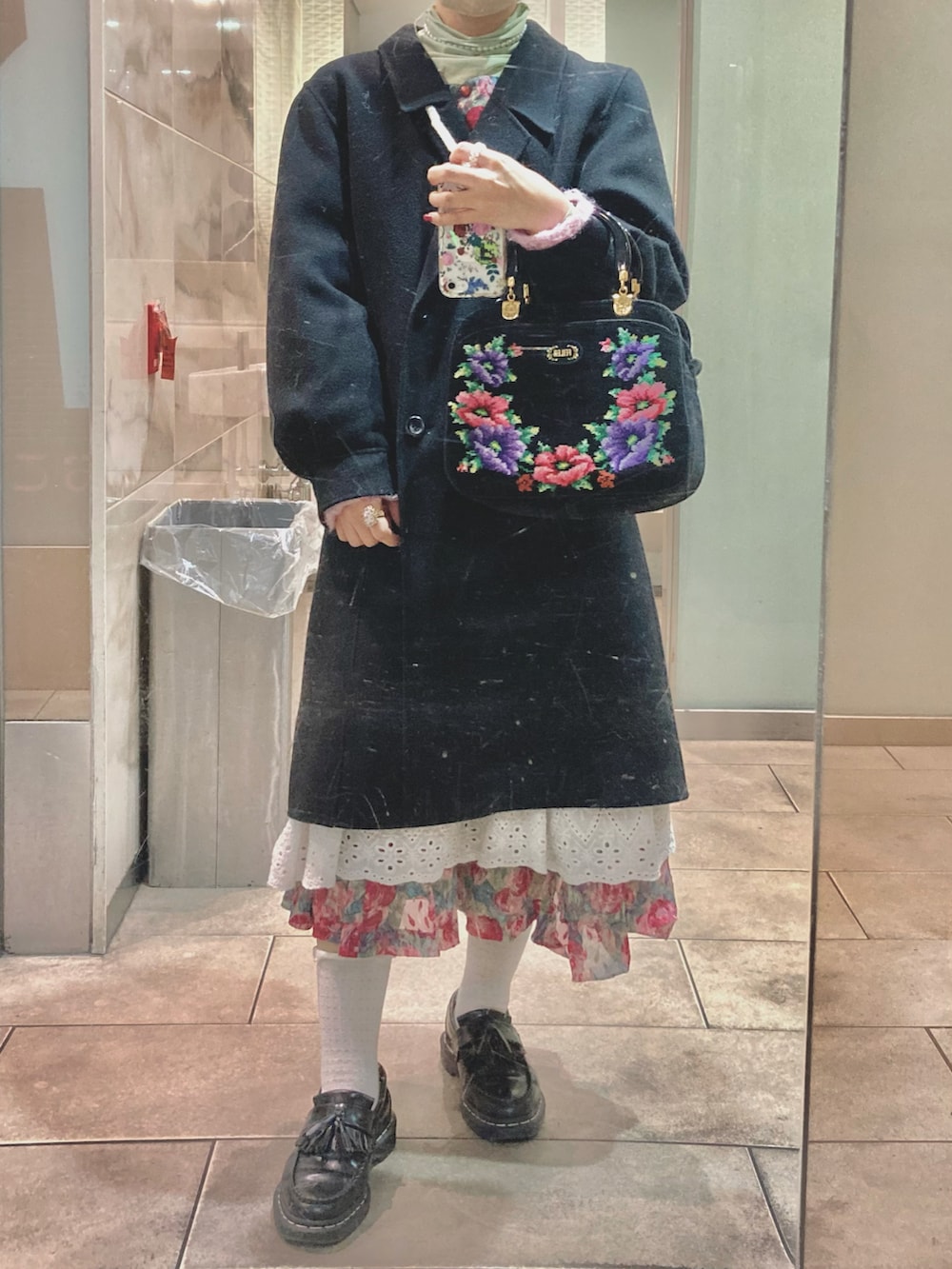 ホワイト系のスカート、ブラック系のローファー、ピンク系のカーディガン/ボレロを着用したレディースの冬コーディネートの2枚目の写真