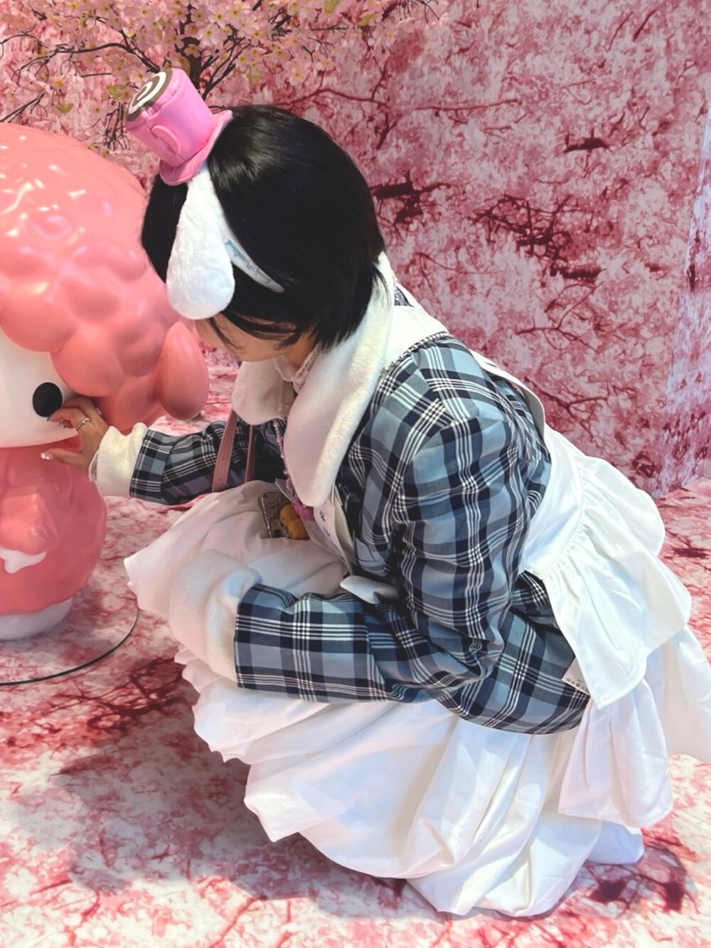 ホワイト系のスカート、シルバー系のスニーカー、ホワイト系のスウェットを着用したレディースの冬コーディネートの3枚目の写真