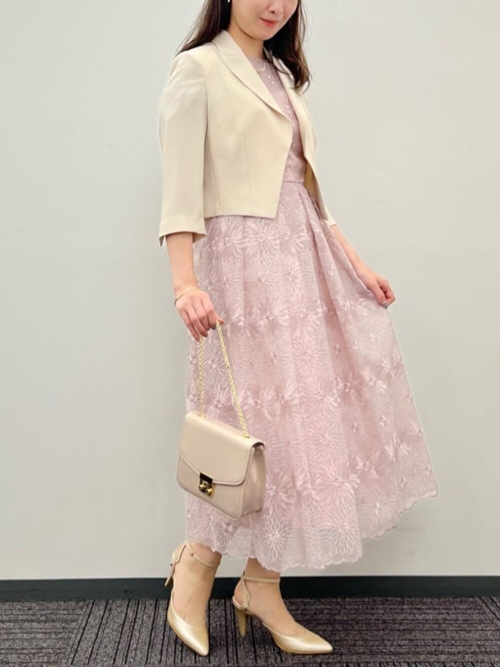 ベージュ系のショルダーバッグ、ベージュ系のパンプス、ピンク系のドレスを着用したレディースの秋コーディネートの2枚目の写真