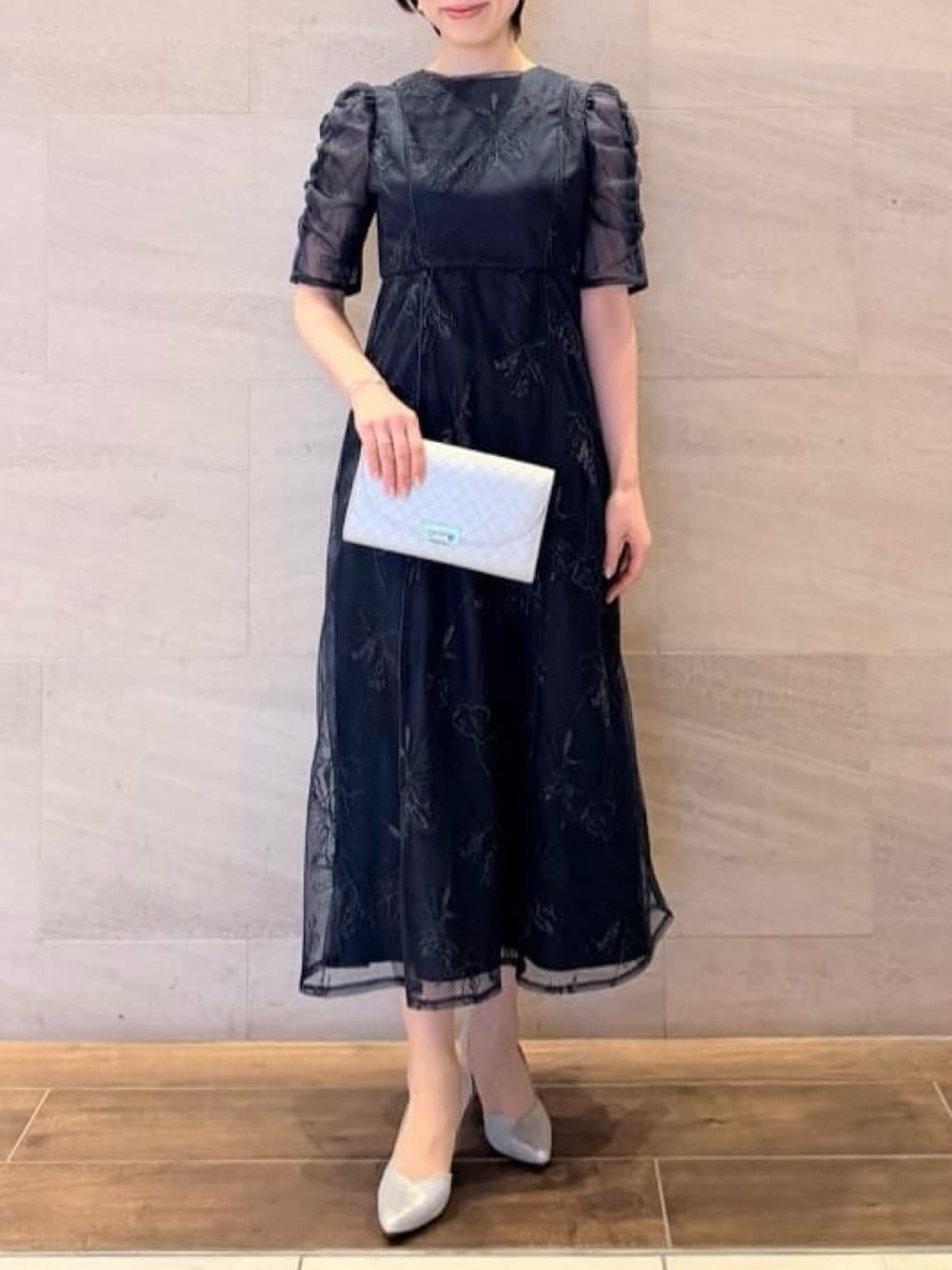 ブルー系のドレス、グレー系のテーラードジャケット、シルバー系のパンプスを着用したレディースの冬コーディネートの2枚目の写真