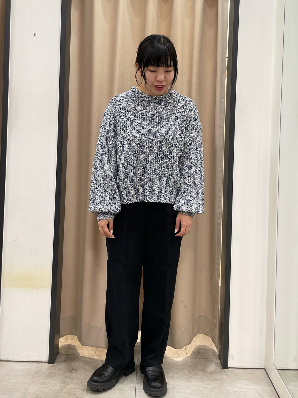 ブルー系のニット/セーター、ホワイト系のハンドバッグ、ブラック系のその他パンツを着用したレディースの冬コーディネートの3枚目の写真