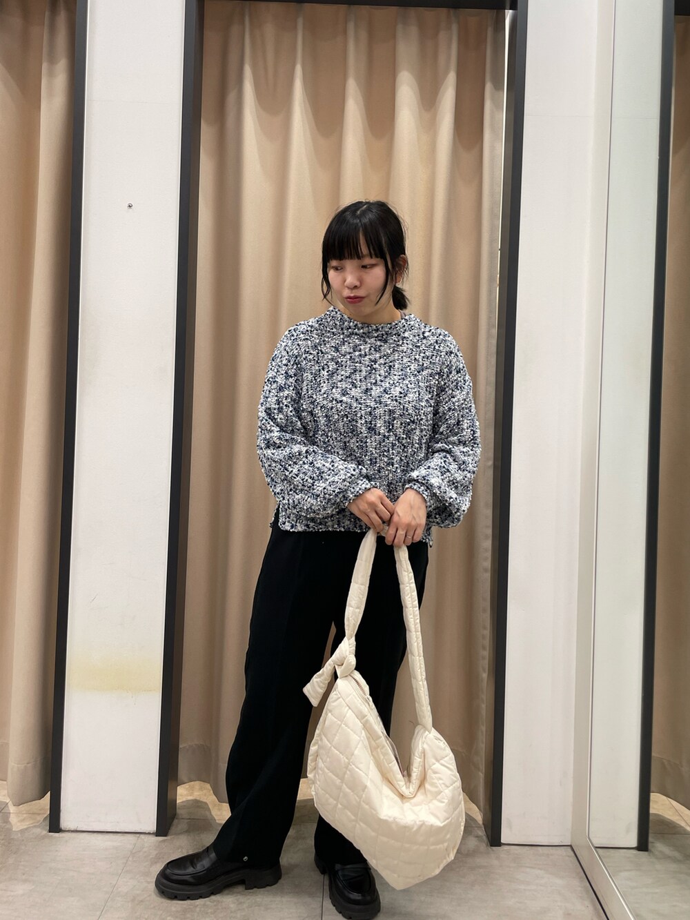 ブルー系のニット/セーター、ホワイト系のハンドバッグ、ブラック系のその他パンツを着用したレディースの冬コーディネートの2枚目の写真