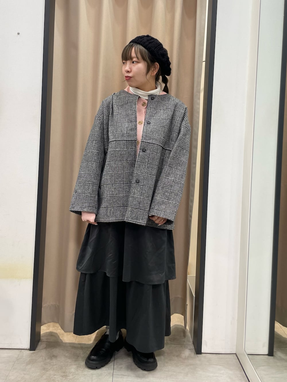 グレー系のスカート、ピンク系のカーディガン/ボレロ、ブラック系のその他アウターを着用したレディースの冬コーディネートの3枚目の写真