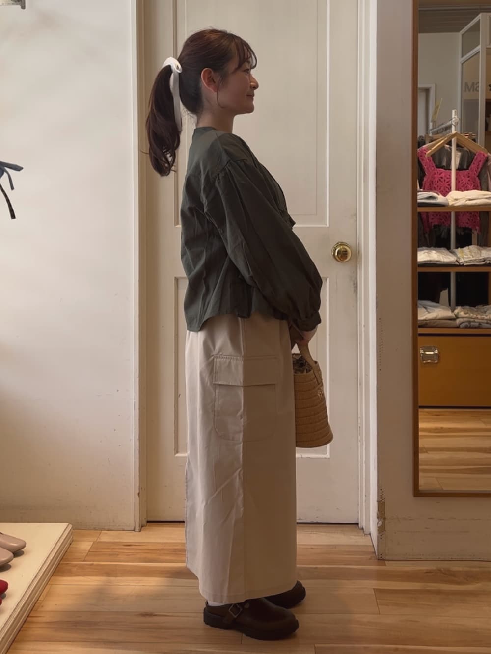 ホワイト系のハンドバッグ、ブルー系のTシャツ/カットソー、グリーン系のブルゾンを着用したレディースの春コーディネートの4枚目の写真