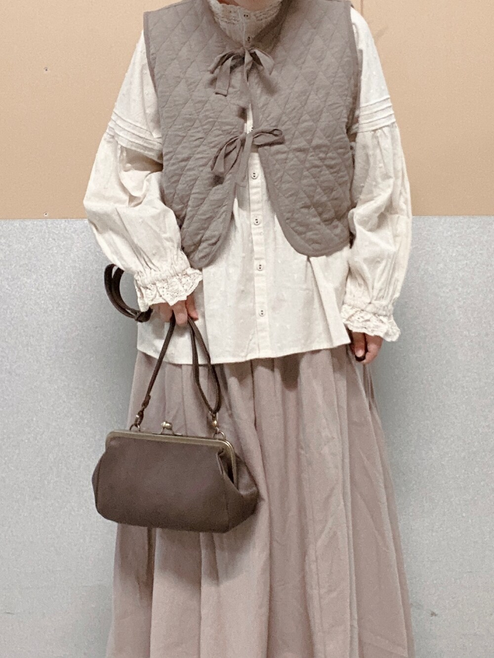 ブラウン系のその他シューズ、ベージュ系のスカート、ブラウン系のハンドバッグを着用したレディースの秋コーディネートの2枚目の写真