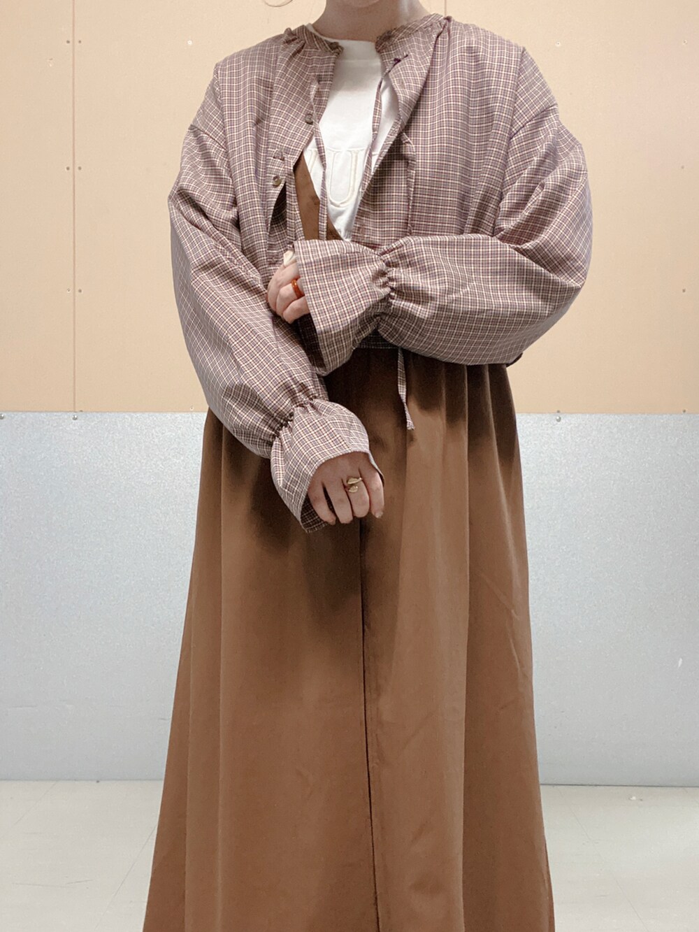 イエロー系のドレスシューズ、ブラウン系のジャンパースカート、ホワイト系のTシャツ/カットソーを着用したレディースの秋コーディネートの2枚目の写真