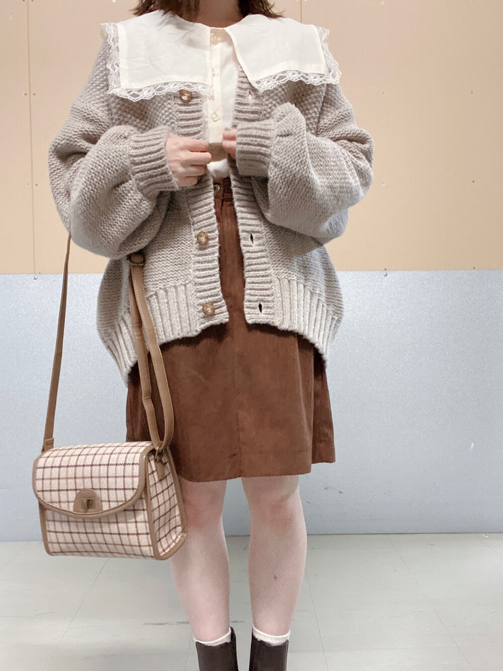 ブラウン系のブーツ、ベージュ系のショルダーバッグ、ベージュ系のカーディガン/ボレロを着用したレディースの秋コーディネートの2枚目の写真