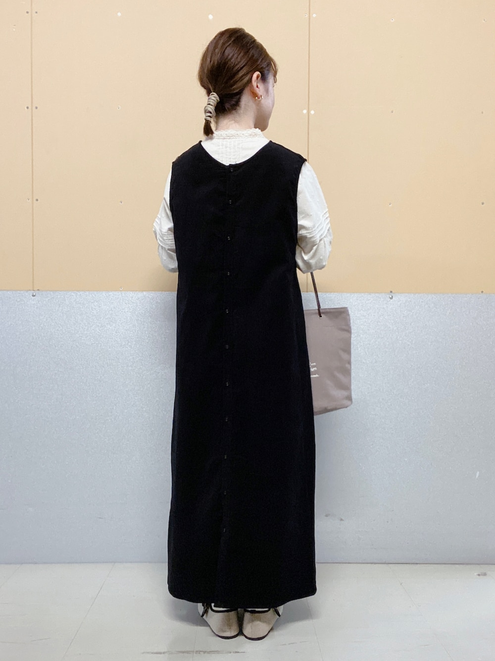 ブラウン系のエコバッグ/サブバッグ、ベージュ系のドレスシューズ、ブラック系のジャンパースカートを着用したレディースの秋コーディネートの2枚目の写真