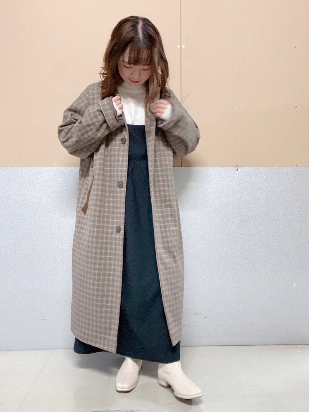 ベージュ系のショルダーバッグ、ベージュ系のブーツ、ブラック系のワンピースを着用したレディースの冬コーディネートの2枚目の写真