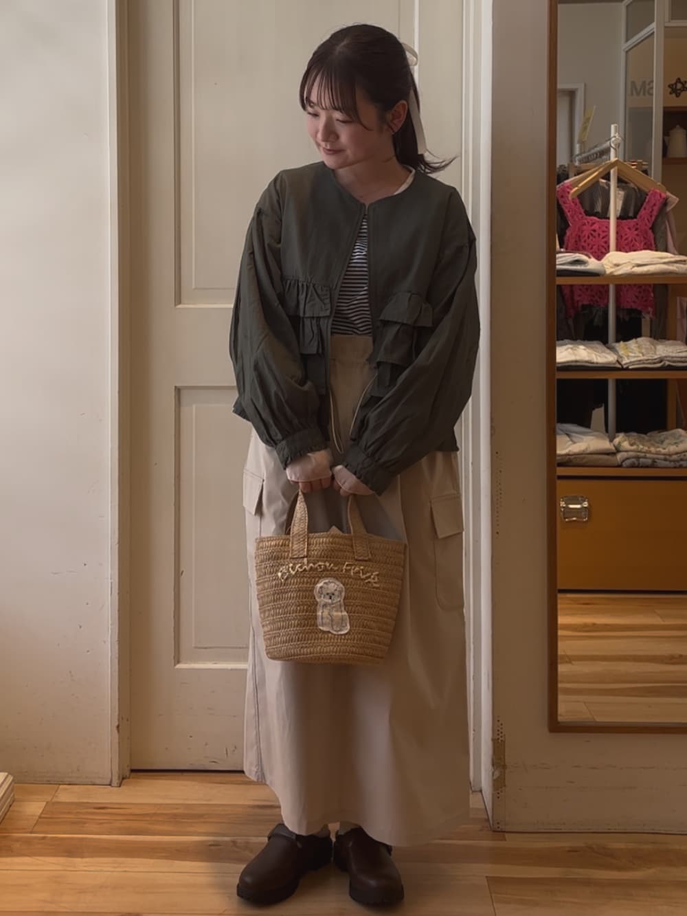 ホワイト系のハンドバッグ、ブルー系のTシャツ/カットソー、グリーン系のブルゾンを着用したレディースの春コーディネートの2枚目の写真