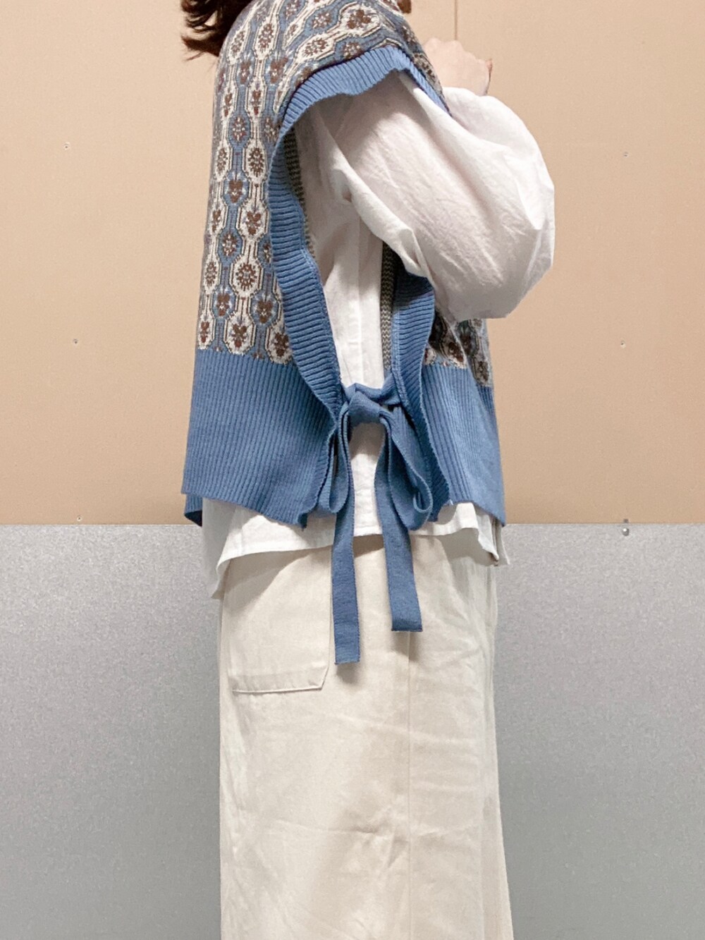 ホワイト系のスカート、ブルー系のベスト、ホワイト系のシャツ/ブラウスを着用したレディースの秋コーディネートの2枚目の写真