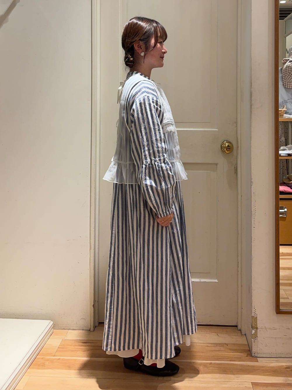 ホワイト系のベスト、ブルー系のワンピース、ホワイト系のスカートを着用したレディースの春コーディネートの2枚目の写真