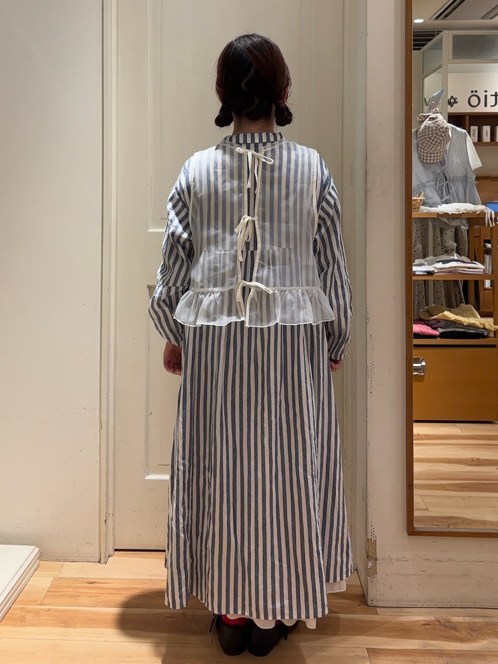 ホワイト系のベスト、ブルー系のワンピース、ホワイト系のスカートを着用したレディースの春コーディネートの3枚目の写真