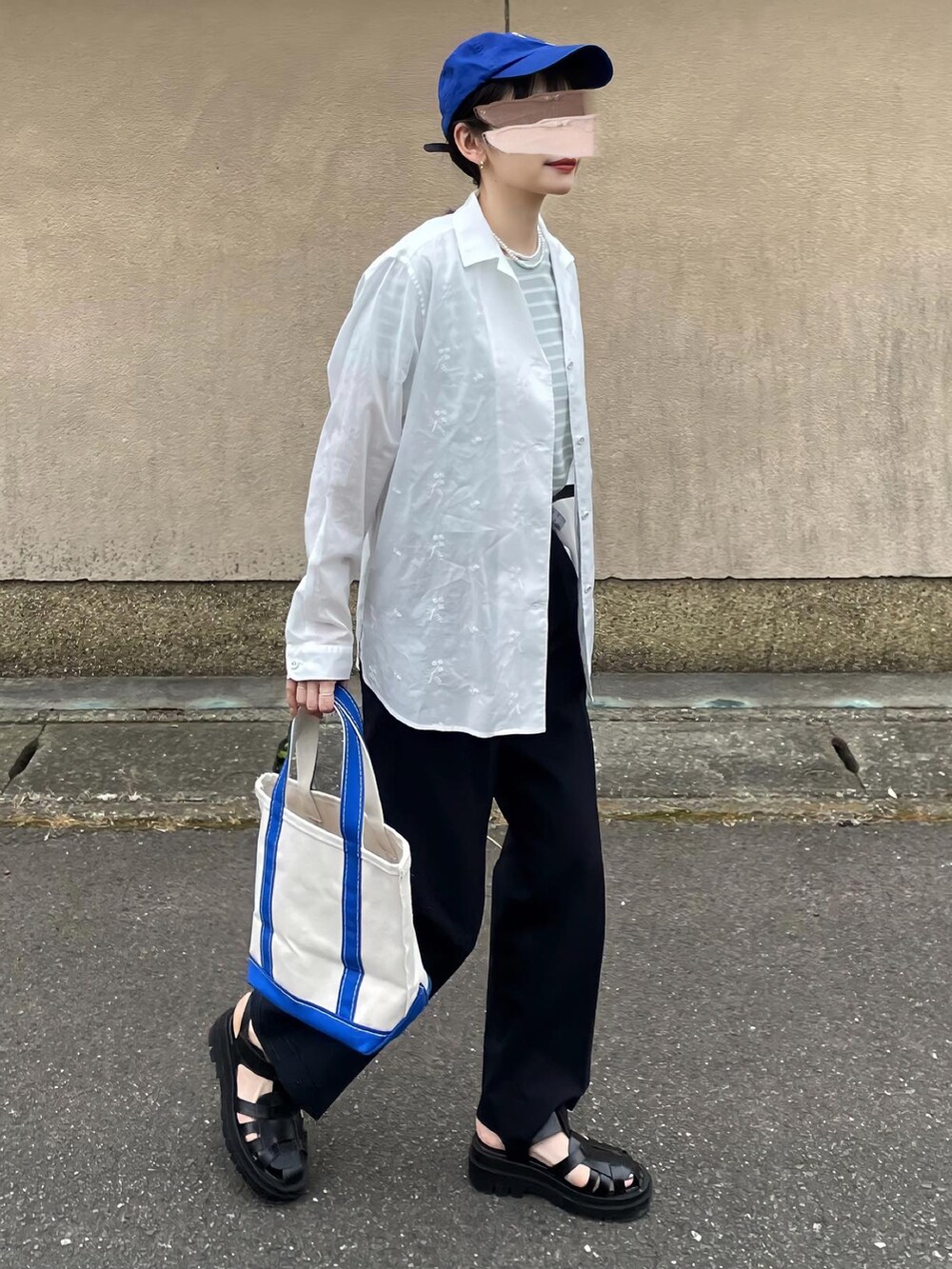 ブルー系のスラックス、ブルー系のトートバッグを着用したレディースの春コーディネートの2枚目の写真