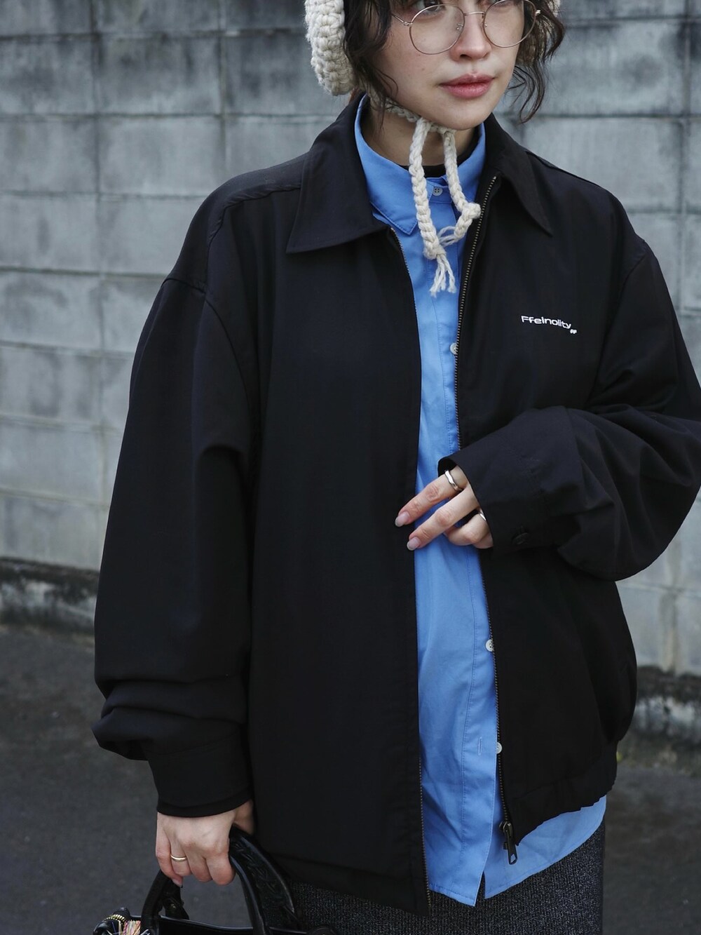 ブラック系のブルゾンを着用したレディースの冬コーディネートの2枚目の写真