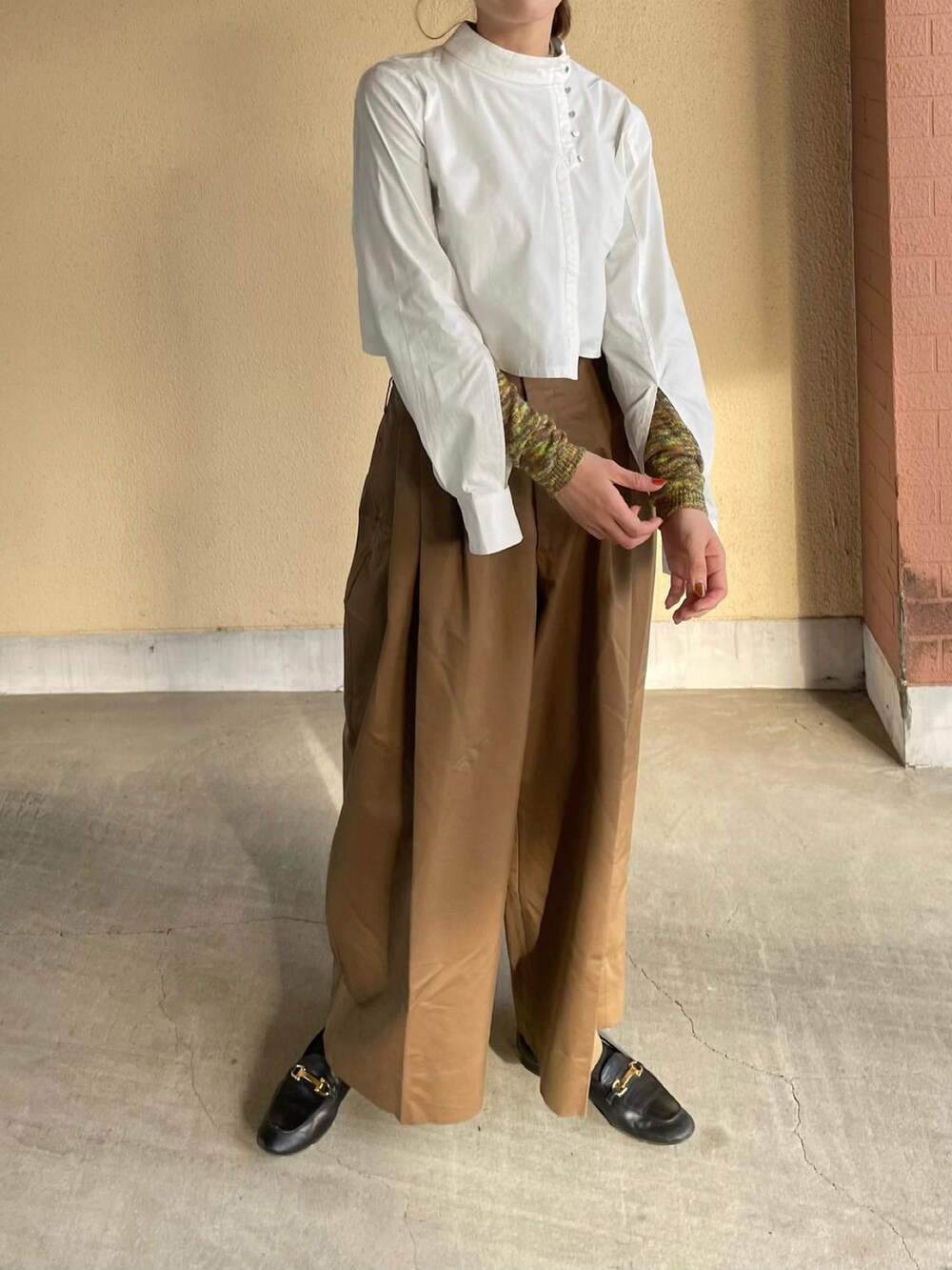 ホワイト系のトップス、イエロー系のニット/セーターを着用したレディースの春コーディネートの2枚目の写真