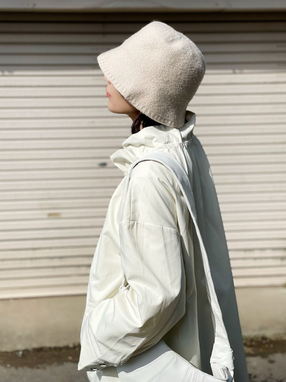 ホワイト系のブルゾン、ブルー系のパンツ、ベージュ系のハットを着用したレディースの春コーディネートの3枚目の写真