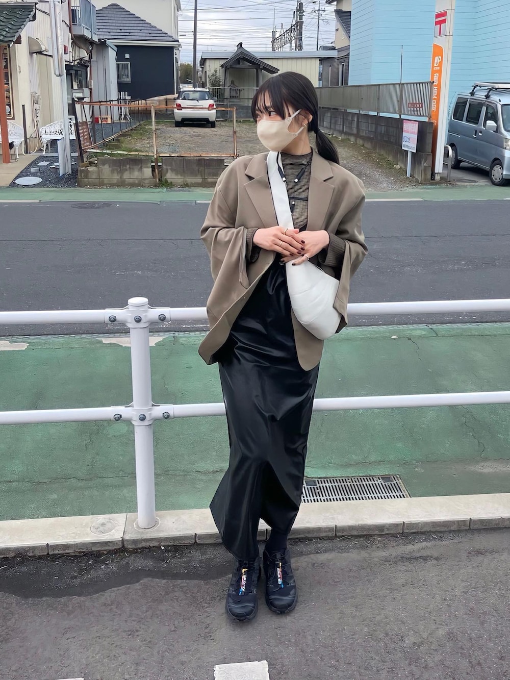 ブラック系のワンピース、ブラック系のスニーカーを着用したレディースの冬コーディネートの2枚目の写真