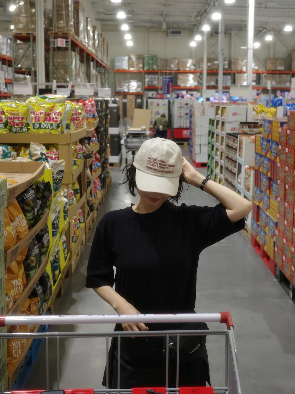 ブラック系のボディバッグ/ウエストポーチ、イエロー系のスニーカー、ベージュ系のキャップを着用したレディースの夏コーディネートの2枚目の写真