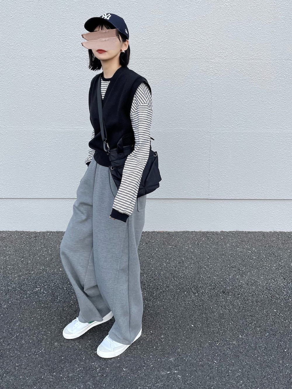 ホワイト系のTシャツ/カットソー、ブラック系のショルダーバッグ、ホワイト系のスニーカーを着用したレディースの春コーディネートの3枚目の写真