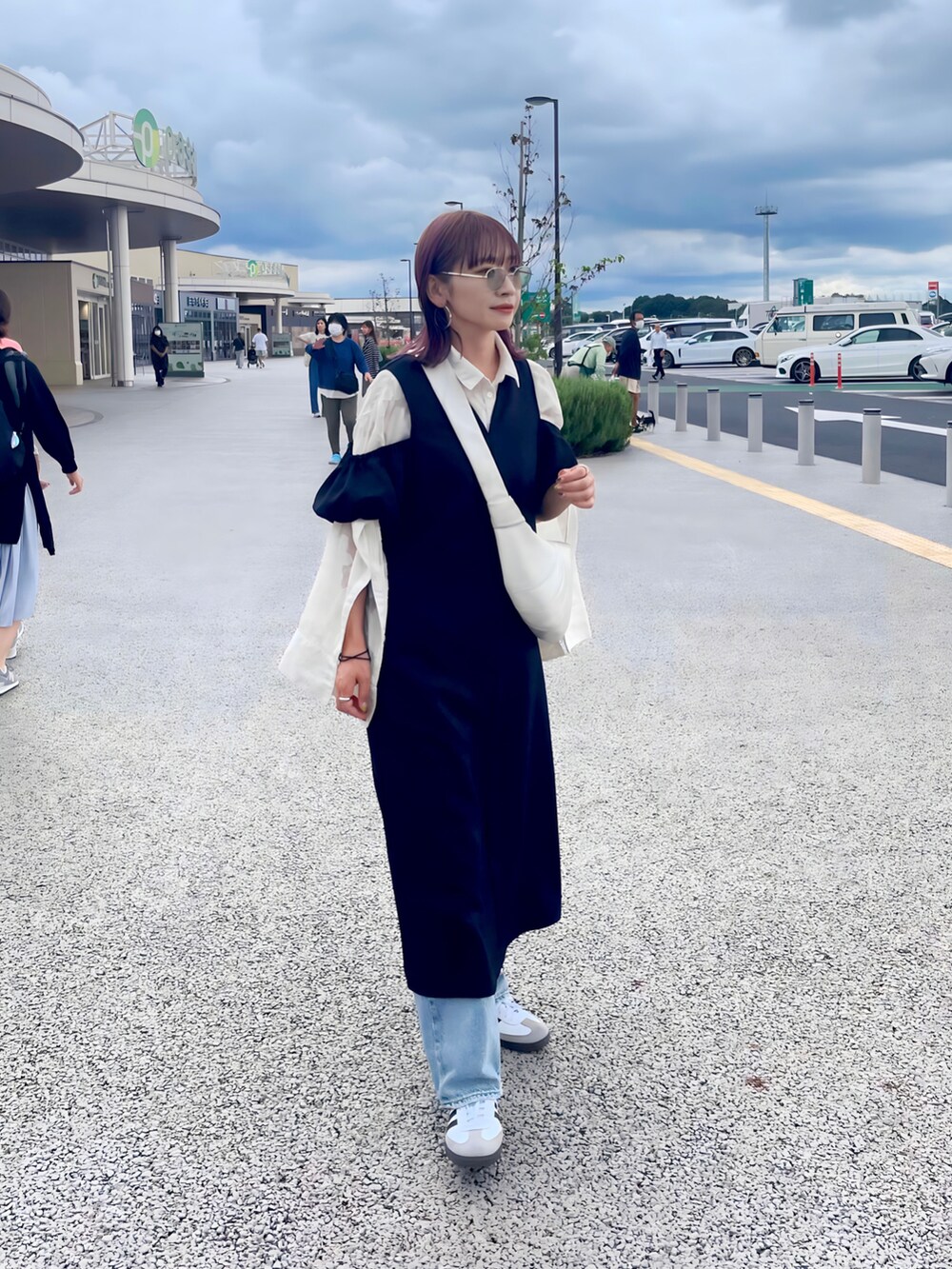 ブラック系のワンピース、ホワイト系のスニーカーを着用したレディースの秋コーディネートの2枚目の写真