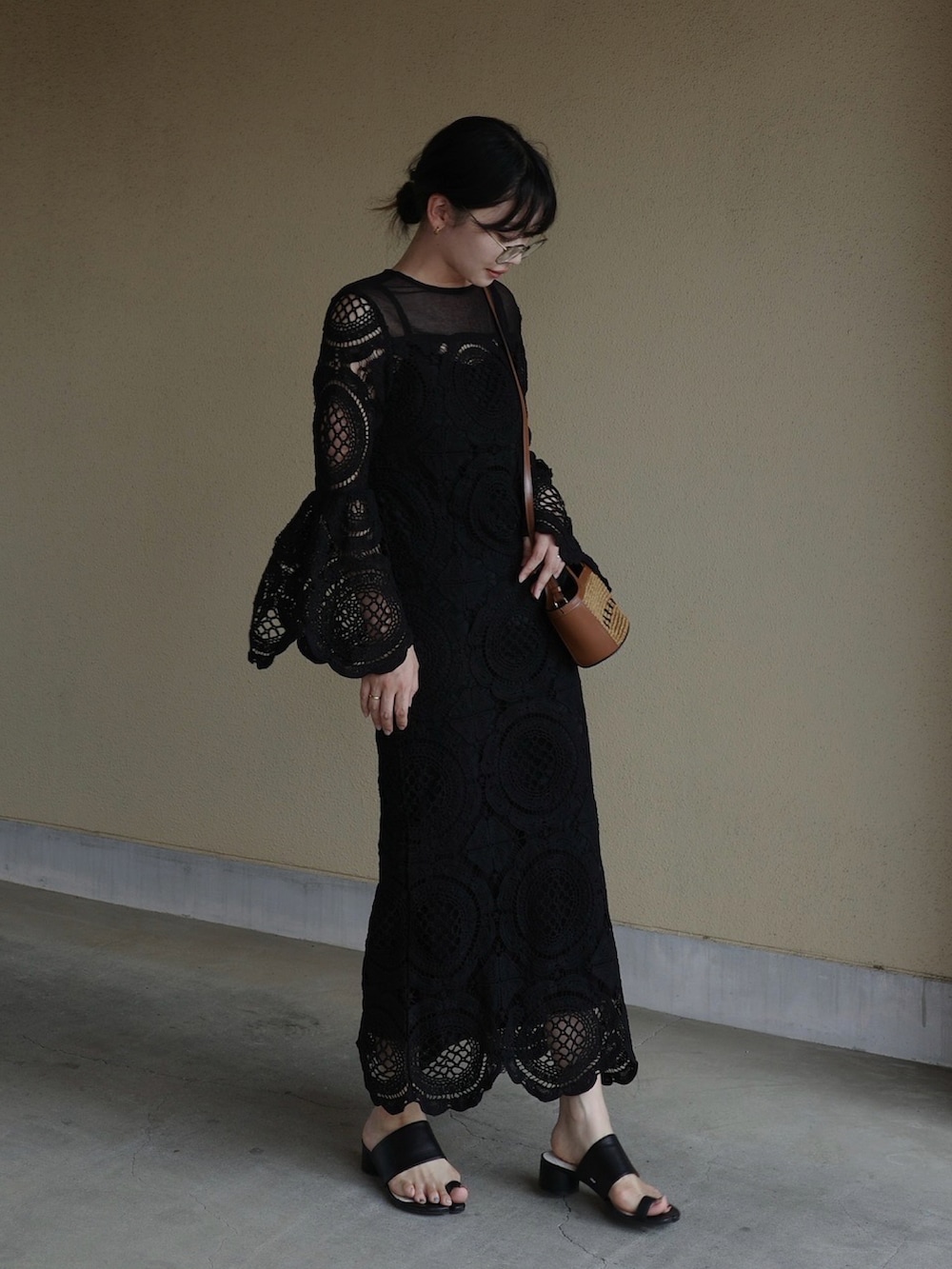 ブラック系のワンピース、ブラック系のサンダルを着用したレディースの夏コーディネートの2枚目の写真