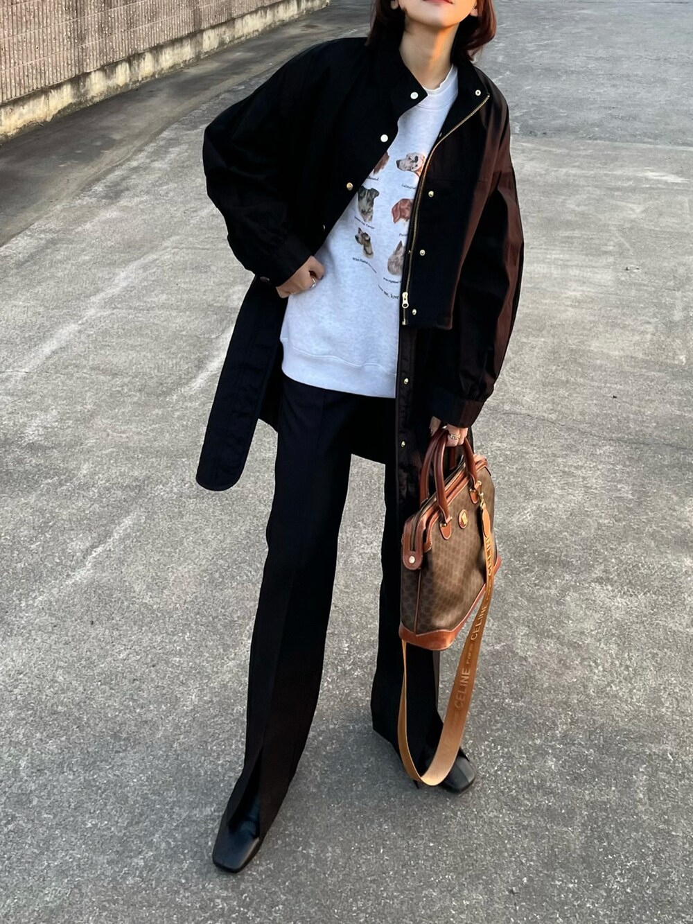 ブラック系のモッズコート、ブラック系のスラックスを着用したレディースの冬コーディネートの2枚目の写真