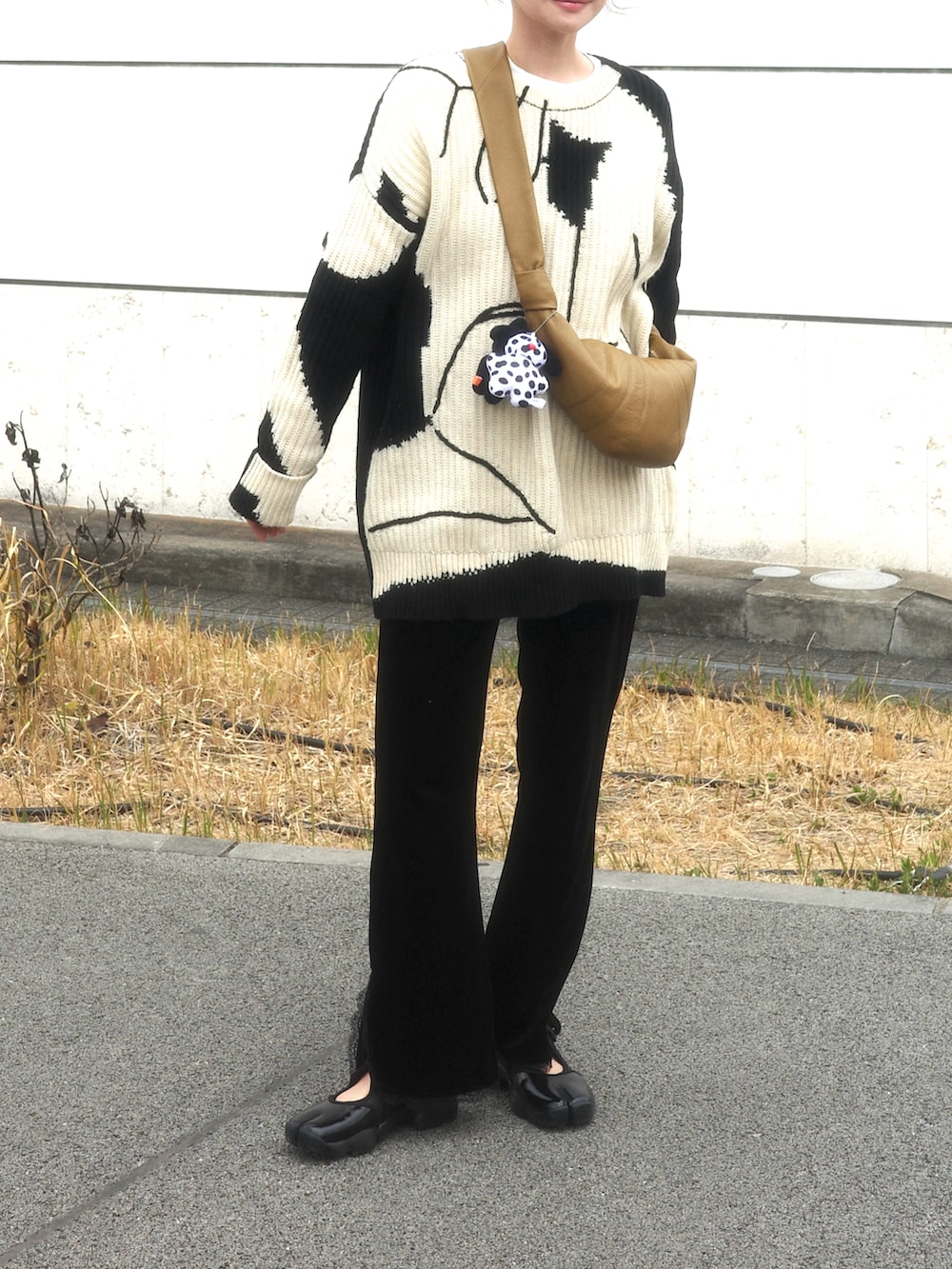ブラック系のスニーカー、ブラック系のニット/セーターを着用したレディースの春コーディネートの2枚目の写真
