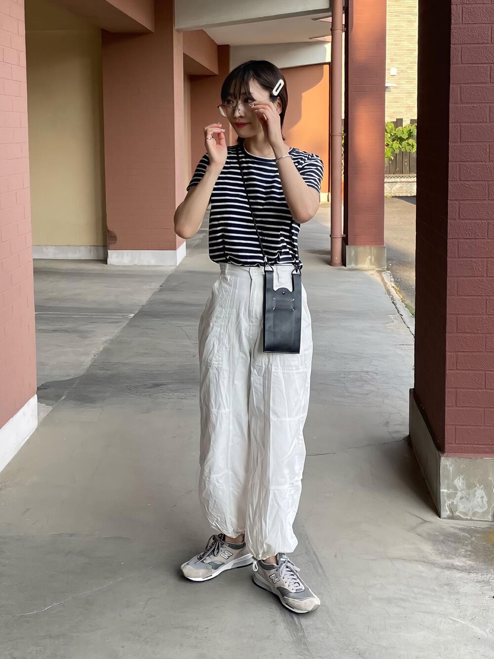 ホワイト系のカーゴパンツ、グレー系のスニーカー、ブラック系のバッグを着用したレディースの春コーディネートの2枚目の写真