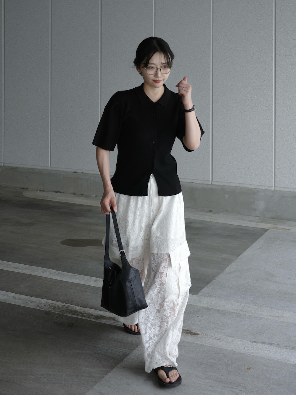 ブラック系のショルダーバッグ、ホワイト系のカーゴパンツ、ブラック系のカーディガン/ボレロを着用したレディースの夏コーディネートの2枚目の写真
