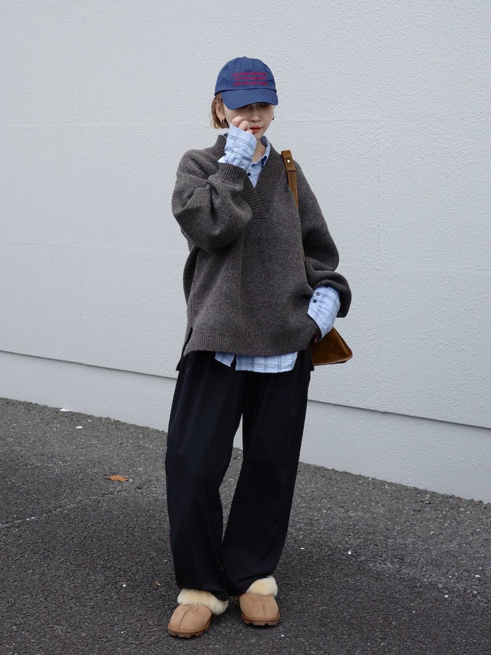 ブラウン系のニット/セーター、ブラウン系のサンダル、ブルー系のシャツ/ブラウスを着用したレディースの秋コーディネートの2枚目の写真