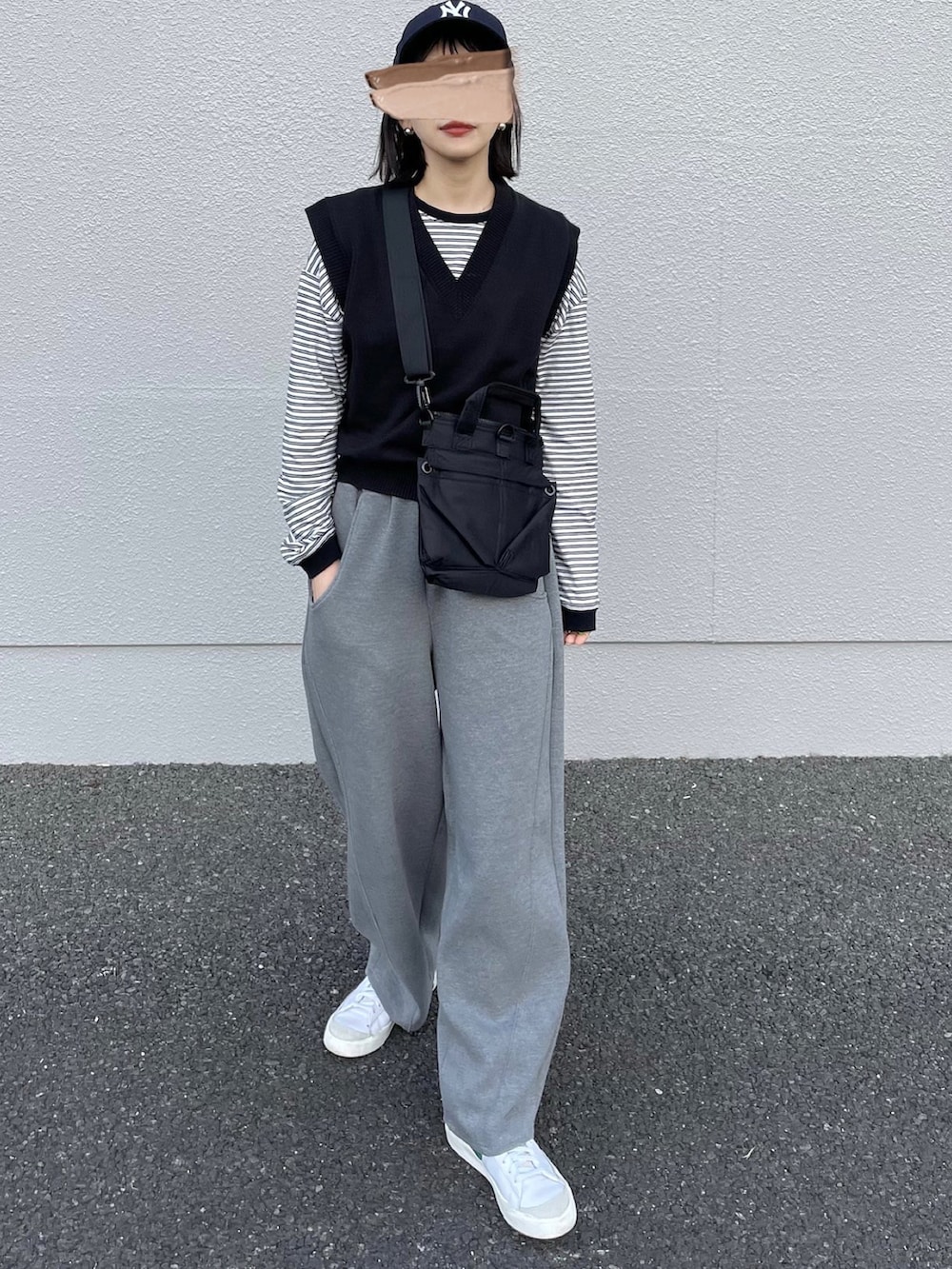 ホワイト系のTシャツ/カットソー、ブラック系のショルダーバッグ、ホワイト系のスニーカーを着用したレディースの春コーディネートの2枚目の写真