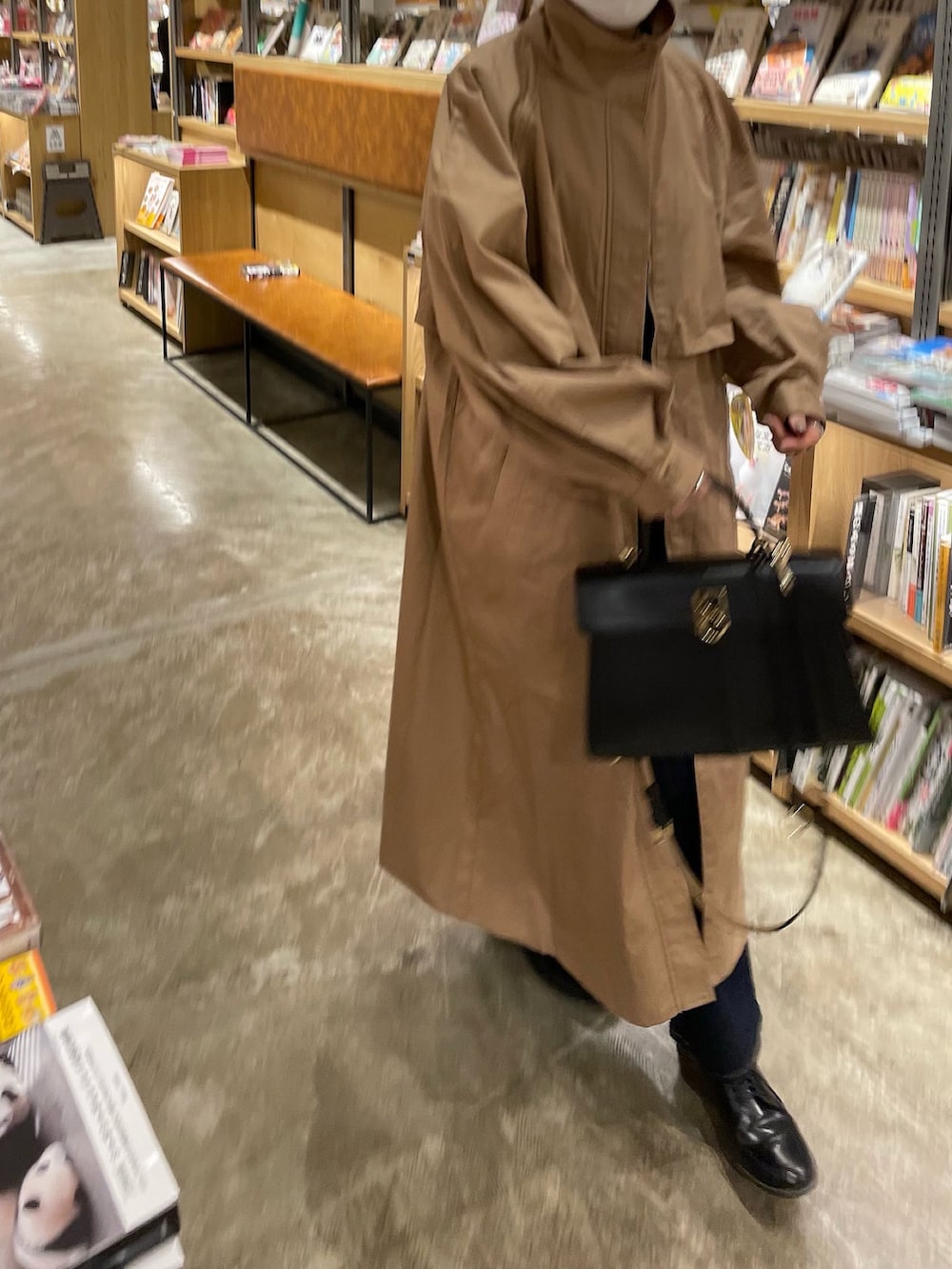 ベージュ系のトレンチコート、ブルー系のデニムパンツを着用したレディースの冬コーディネートの3枚目の写真