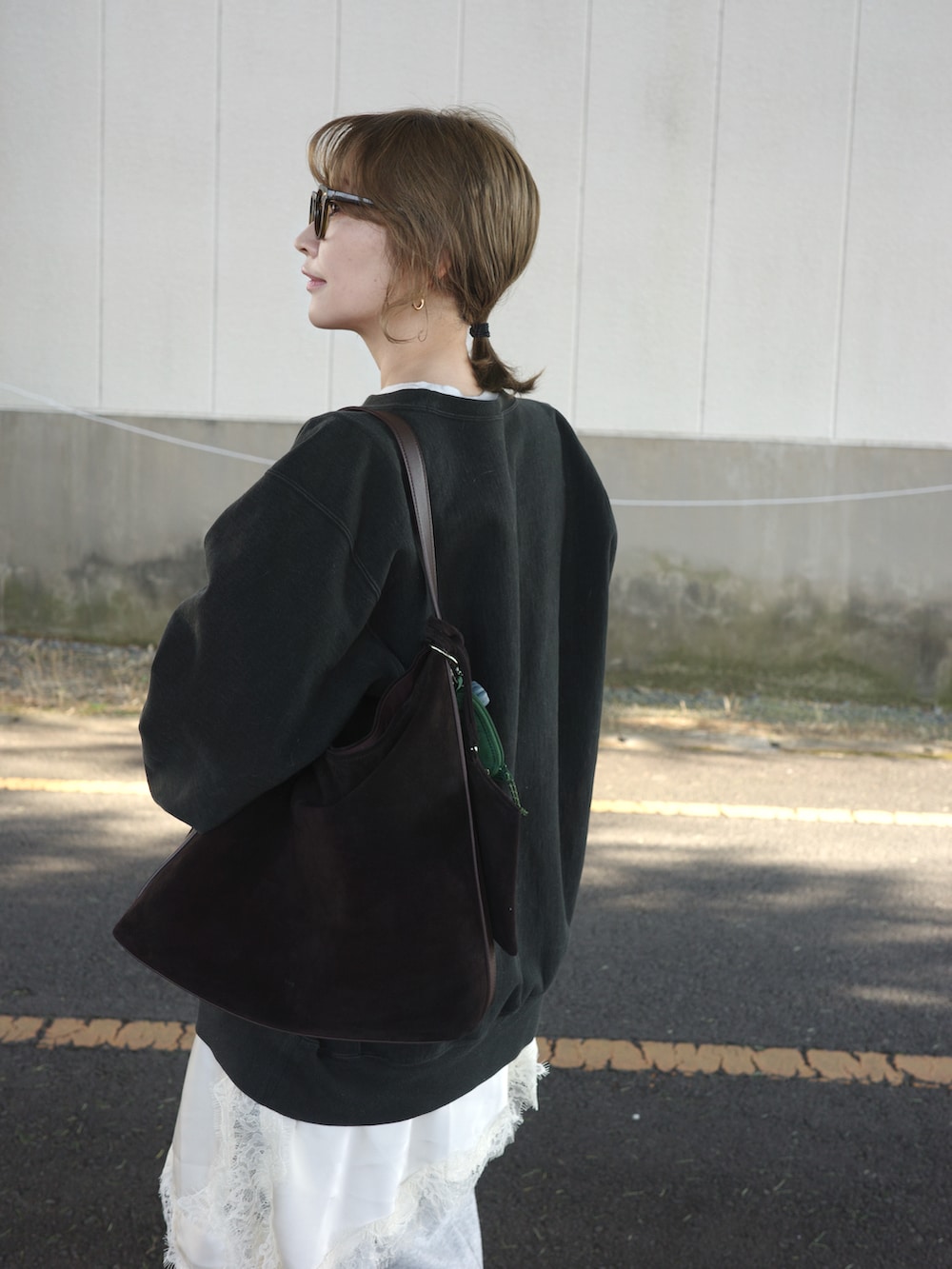 ブラック系のトップス、イエロー系のスニーカーを着用したレディースの冬コーディネートの2枚目の写真