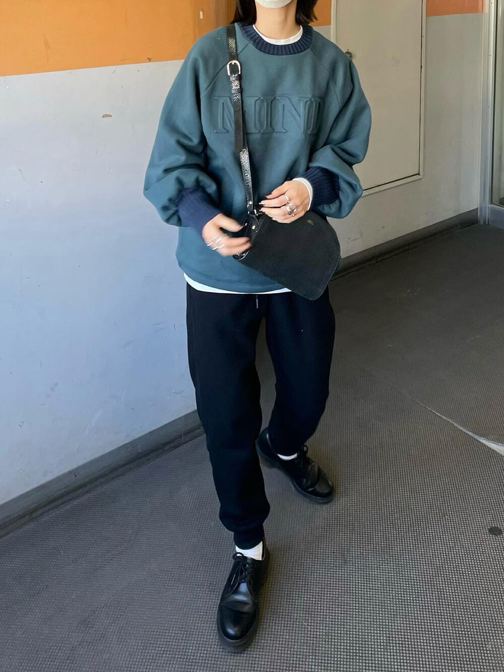グリーン系のスウェット、ブラック系のスウェットパンツ、シルバー系のリングを着用したレディースの冬コーディネートの2枚目の写真
