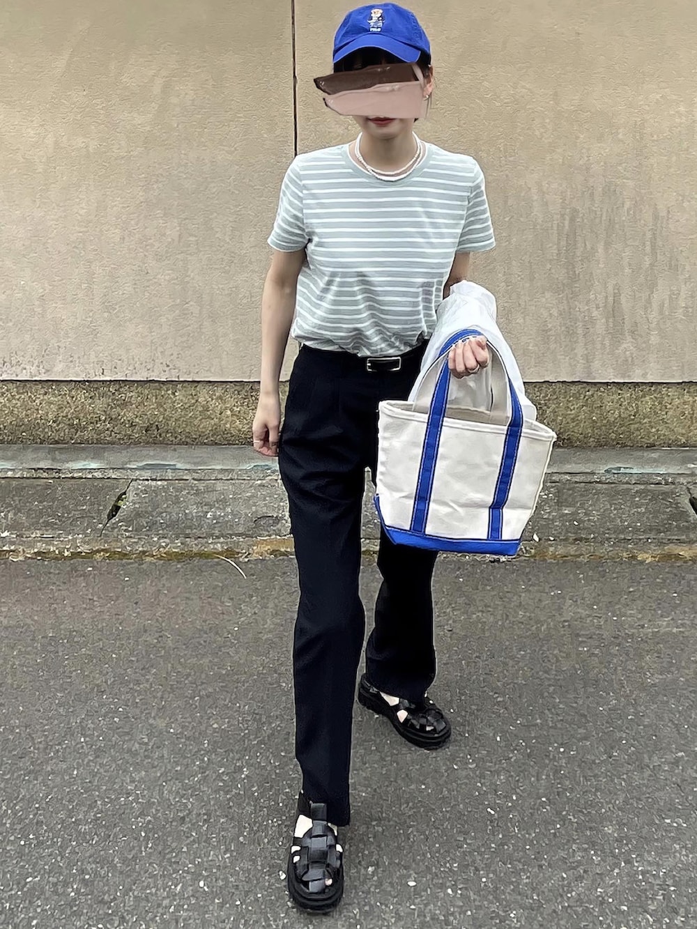 ブルー系のスラックス、ブルー系のトートバッグを着用したレディースの春コーディネートの3枚目の写真