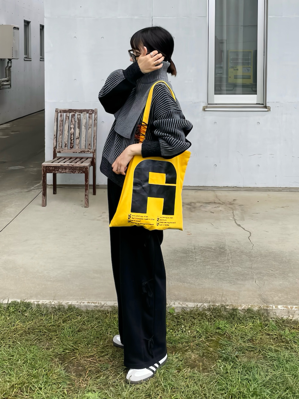 ブラック系のニット/セーター、ホワイト系のスニーカーを着用したレディースの秋コーディネートの2枚目の写真