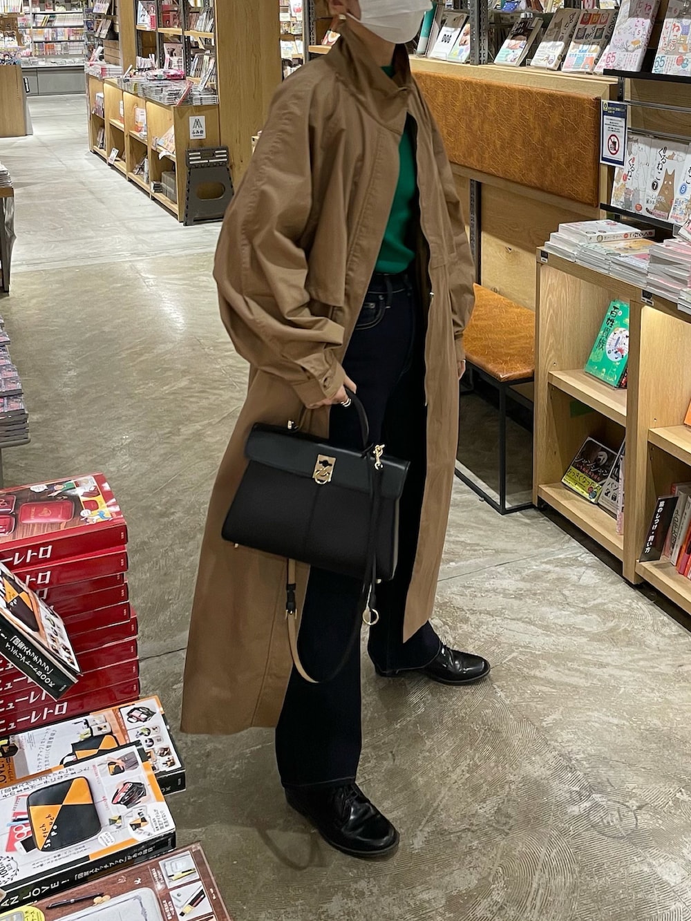 ベージュ系のトレンチコート、ブルー系のデニムパンツを着用したレディースの冬コーディネートの2枚目の写真