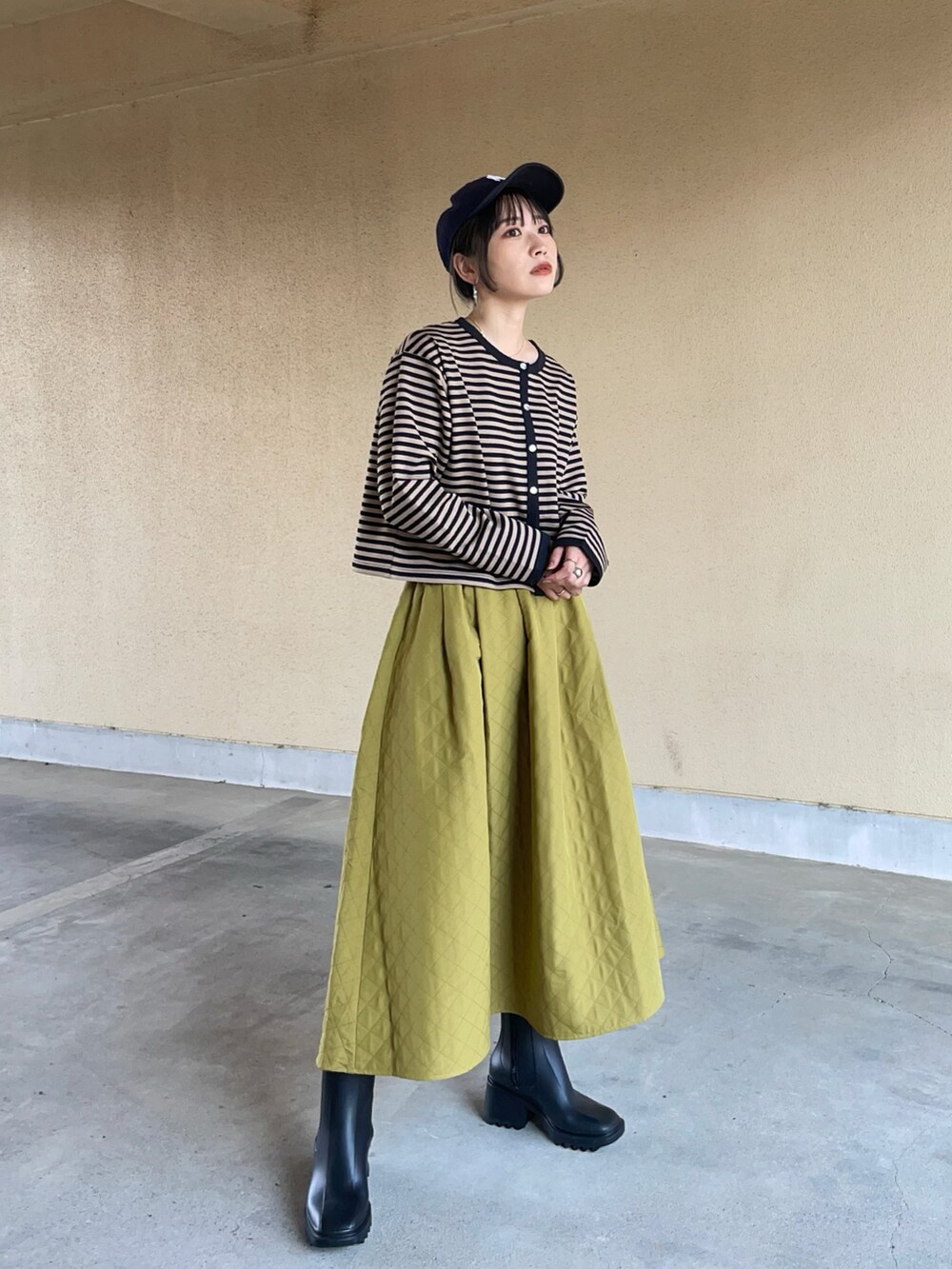 ブラック系のレインシューズ、ブルー系のキャップを着用したレディースの夏コーディネートの2枚目の写真