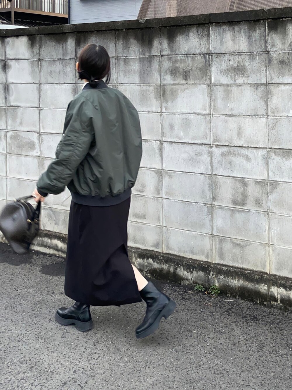 グリーン系のMA-1、ブラック系のジャンパースカートを着用したレディースの秋コーディネートの4枚目の写真