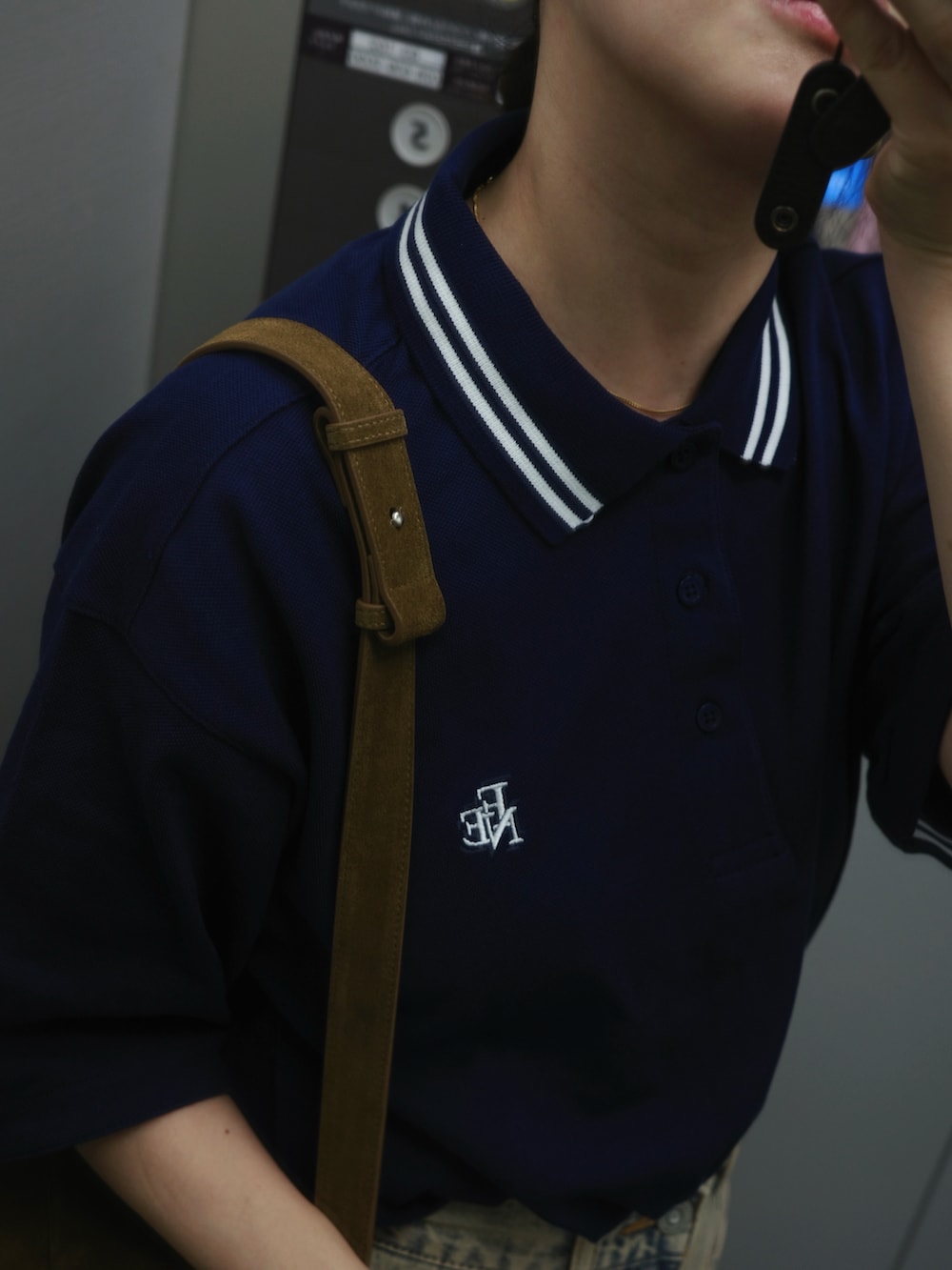 ブルー系のポロシャツ、ブルー系のデニムパンツ、イエロー系のショルダーバッグを着用したレディースの春コーディネートの5枚目の写真