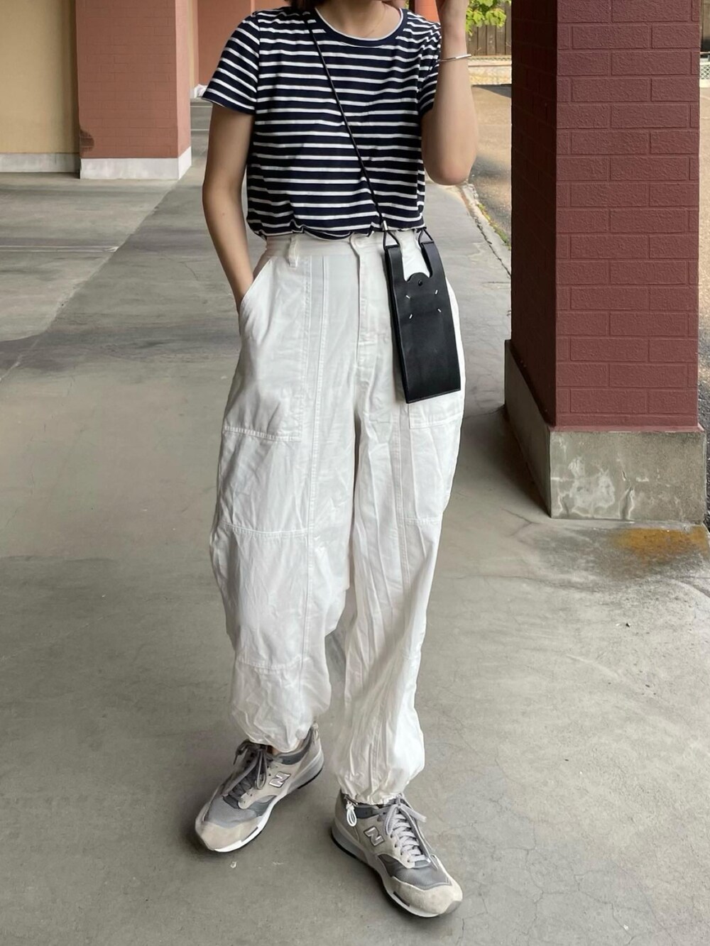 ホワイト系のカーゴパンツ、グレー系のスニーカー、ブラック系のバッグを着用したレディースの春コーディネートの3枚目の写真