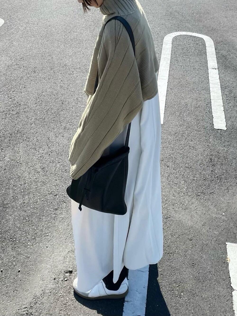 グリーン系のワンピース、ブラック系のショルダーバッグを着用したレディースの秋コーディネートの4枚目の写真