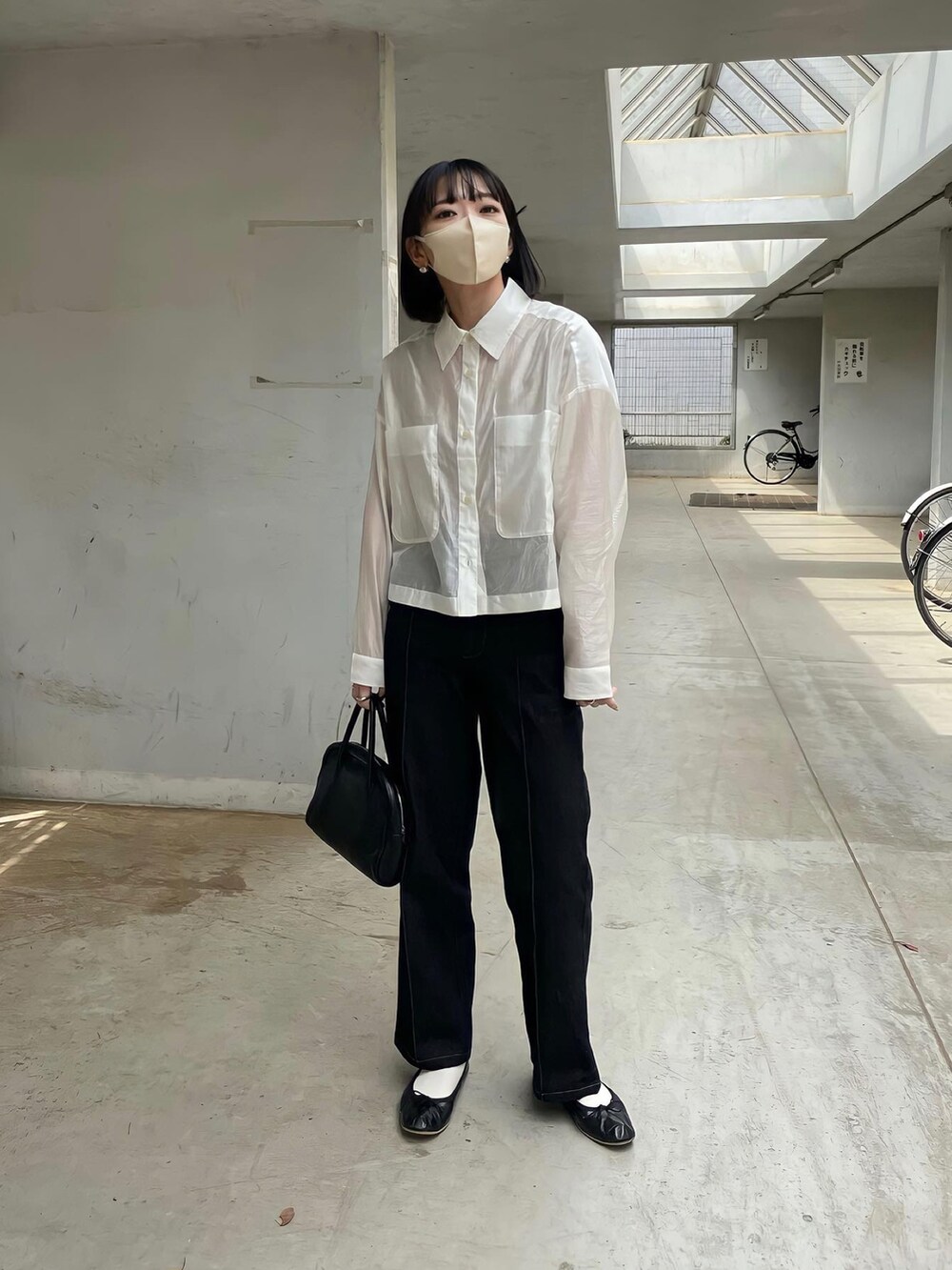 ホワイト系のトップス、ブラック系のバレエシューズを着用したレディースの春コーディネートの3枚目の写真